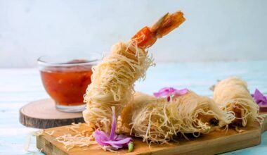 Gambas envueltas en pasta kadaif crujiente sobre una tabla de madera
