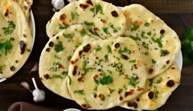 Pan naan recién horneado espolvoreado con semillas de sésamo y perejil fresco