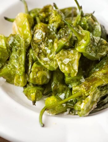 Pimientos de Padrón fritos en un plato con sal gruesa